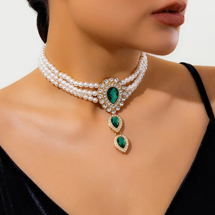 Chic gold bracelet with delicate pearls and sparkling emeralds, part of a women's fashion jewelry set.