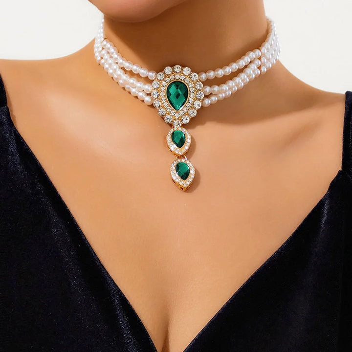 Sparkling emeralds and luminous pearls on a gold women's bracelet from a complete jewelry set, a chic accessory.