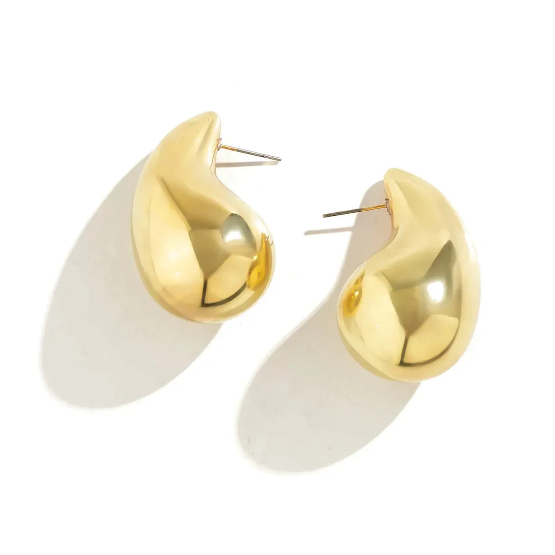 Gold coloured drop earrings for women, featuring brilliant sparkling crystals, a chic fashion accessory.