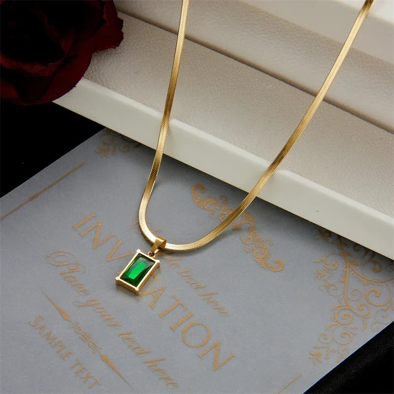 Elegant women's gold plated jewelry set with radiant emerald green stones, including necklace & earrings.