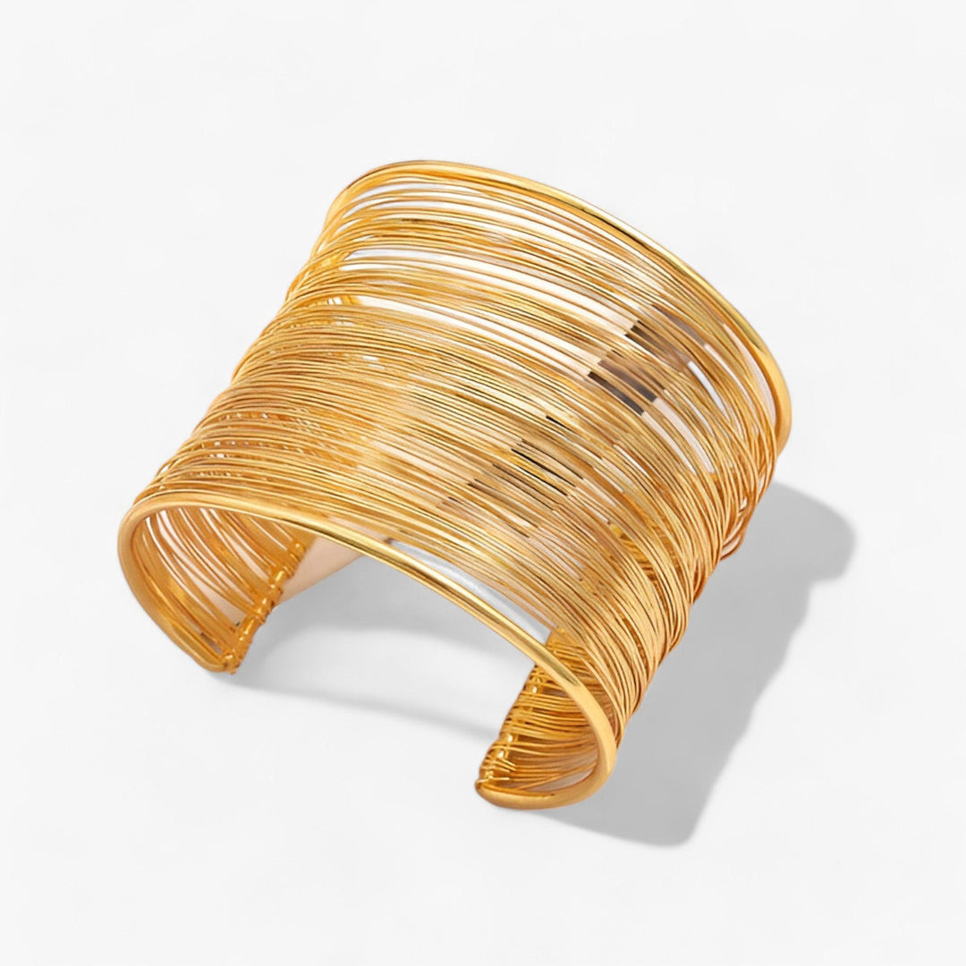 Close-up of a women's gold plated layered wire cuff bracelet, showcasing intricate design.