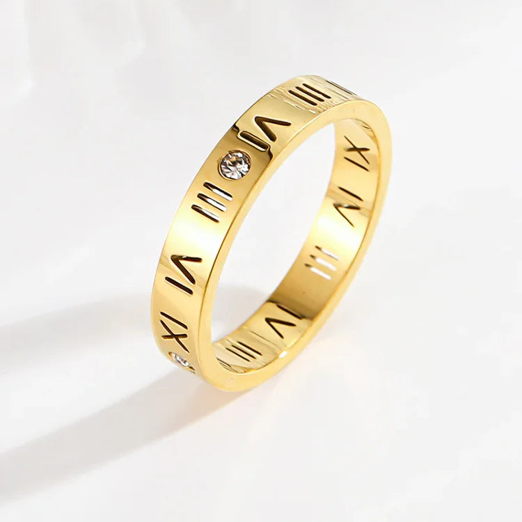 Close-up of women's gold & rose gold Roman numeral ring, an elegant and intricate jewelry design.