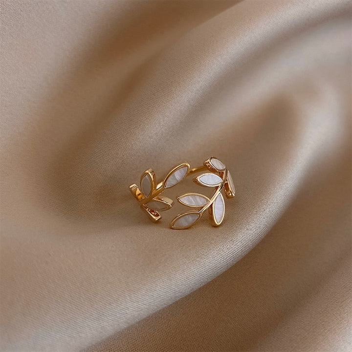 Close-up of a women's golden leaf ring, featuring a delicate, nature-inspired design. Elegant gold jewelry gift.