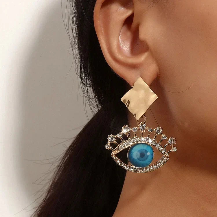 Golden vintage women's evil eye drop earrings, elegant protective jewelry with sparkling rhinestones.