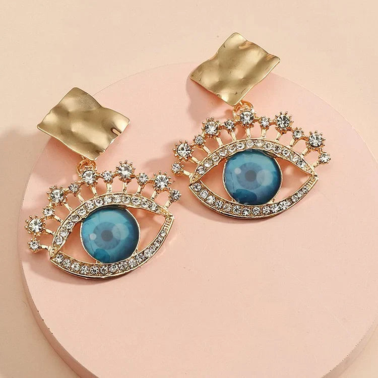 Delicate women's vintage gold evil eye drop earrings with intricate design and sparkling rhinestones.