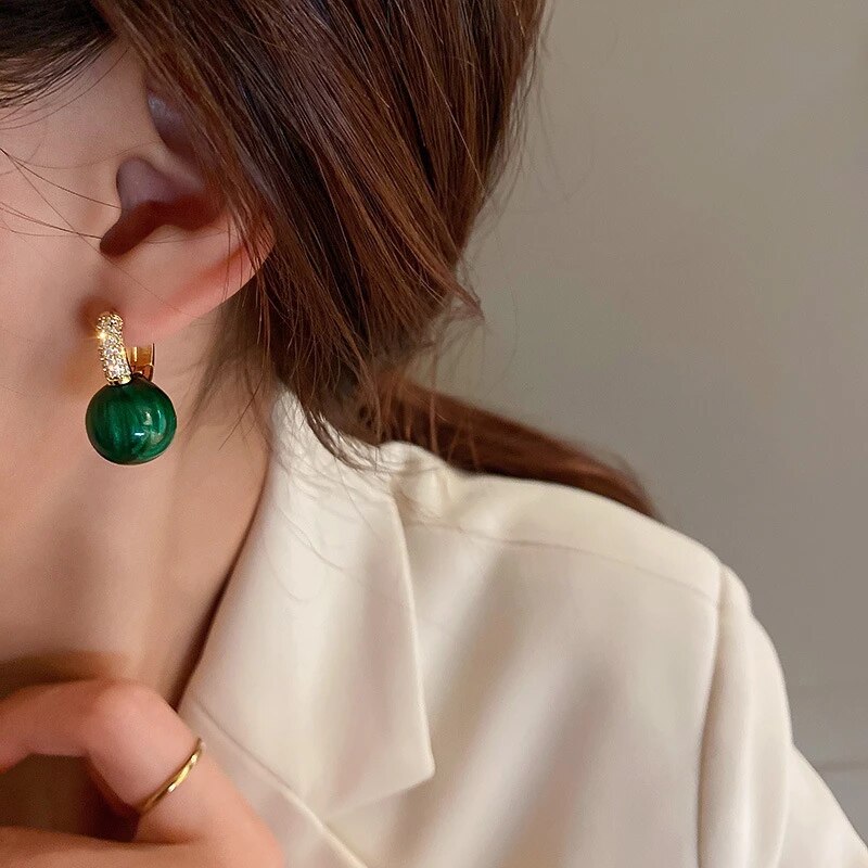 Stunning green gold pearl drop earrings for women. Fashionable and elegant jewelry, ideal for special occasions.