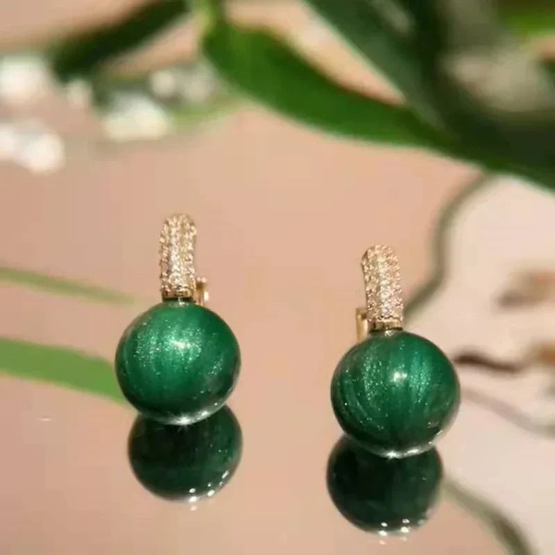 Green gold pearl drop earrings. Exquisite women's jewelry, an elegant and stylish accessory with a unique design.