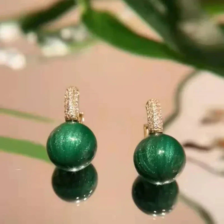 Green gold pearl drop earrings. Exquisite women's jewelry, an elegant and stylish accessory with a unique design.