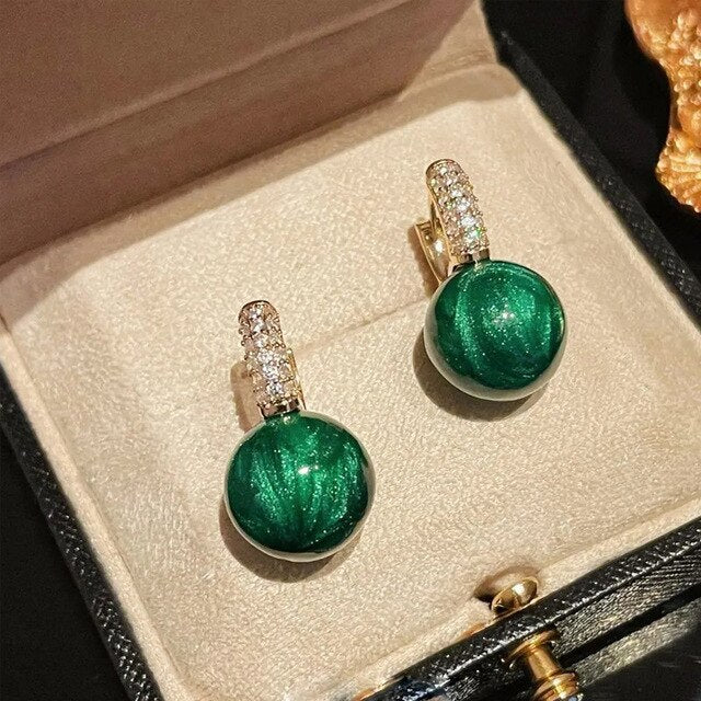 Women's elegant green and gold pearl drop earrings. Delicate gold jewelry with luminous green pearls, a timeless gift.