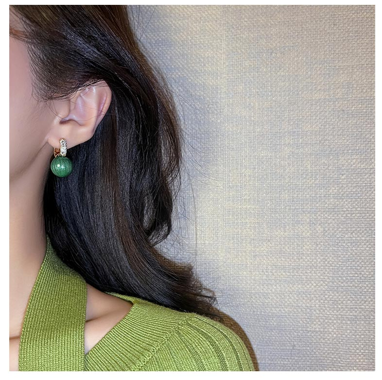 Gold plated drop earrings featuring stunning green pearls, a chic accessory for women's elegant fashion.