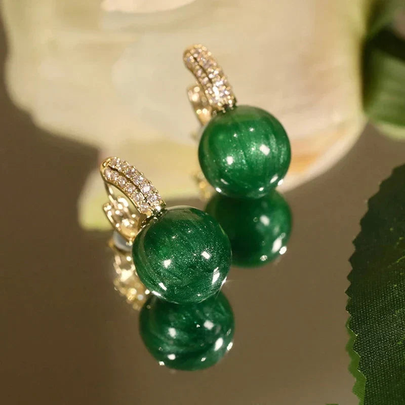 Women's elegant green pearl statement earrings, gold plated, adding a touch of luxury to any outfit.