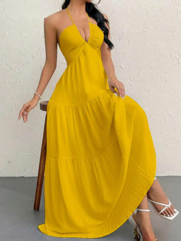 Chic women's halter neck maxi dress featuring an elegant flowing tiered skirt, ideal for summer parties & events.