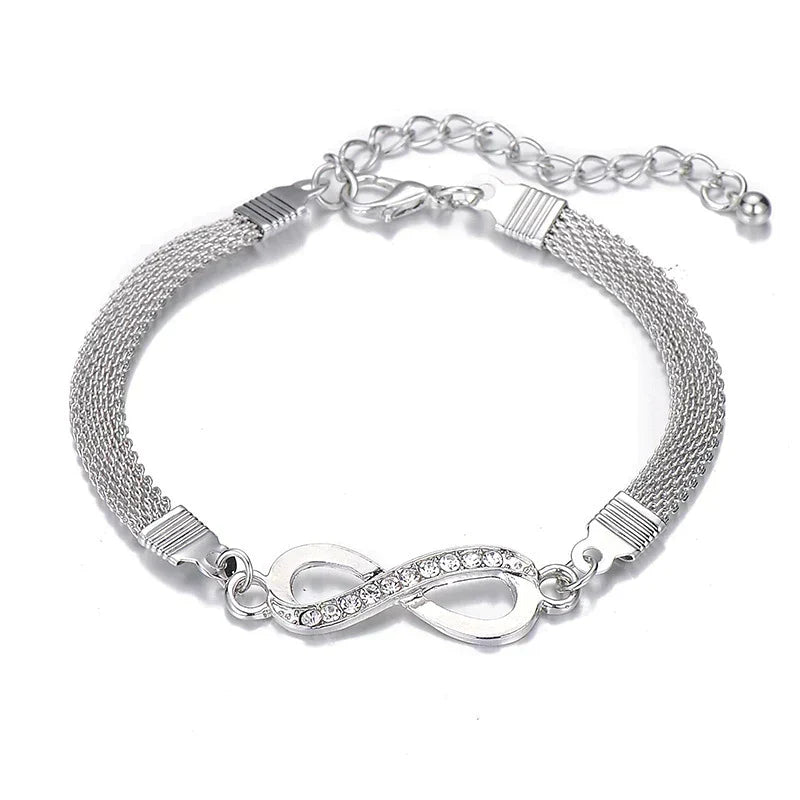Close-up of elegant women's infinity bracelet, showcasing intricate crystal details on a silver band.