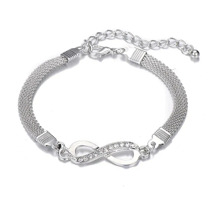 Close-up of elegant women's infinity bracelet, showcasing intricate crystal details on a silver band.