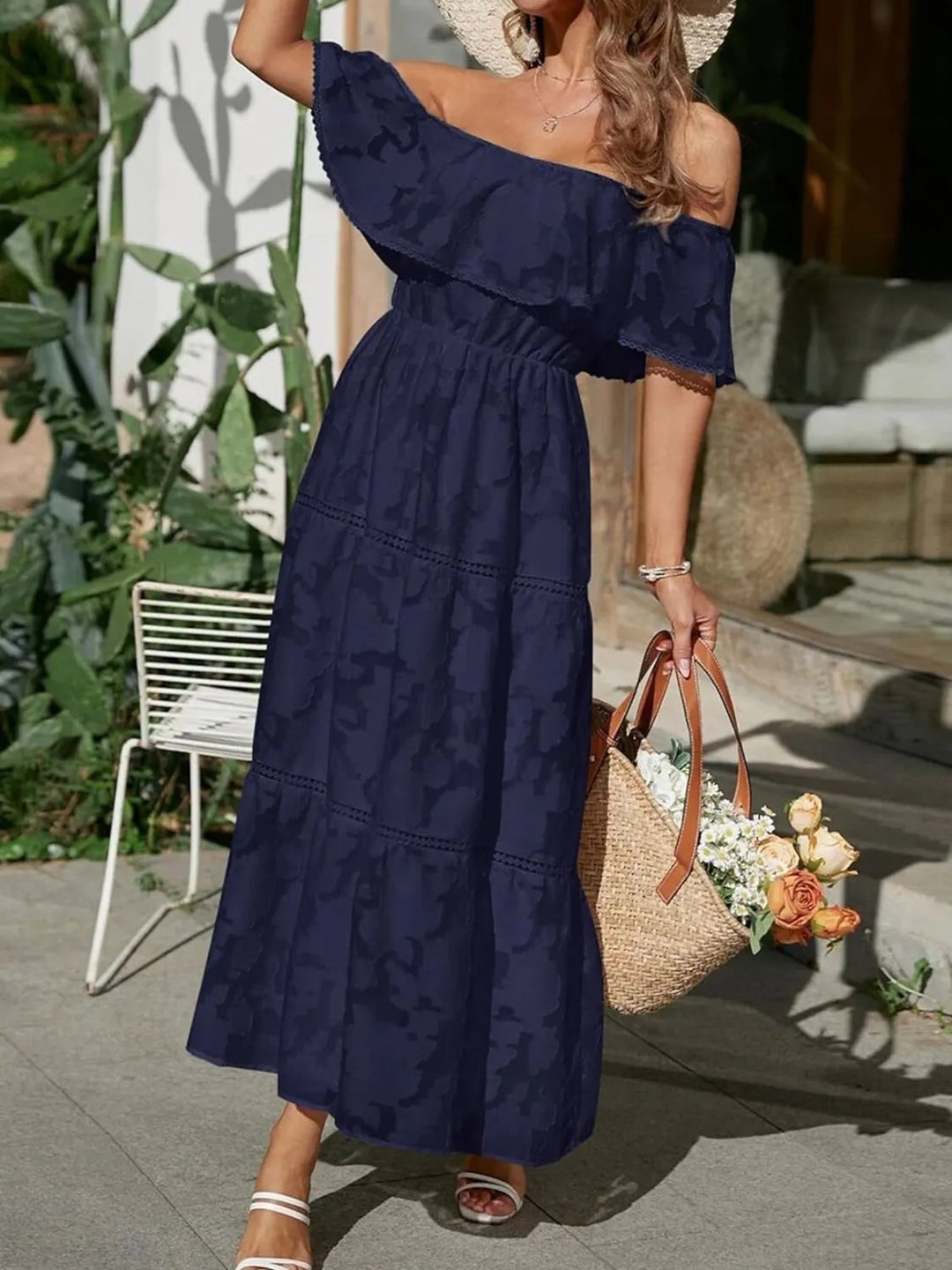 Side profile of women's flowy jacquard off-shoulder maxi dress, showcasing tiered ruffles & lace trim.