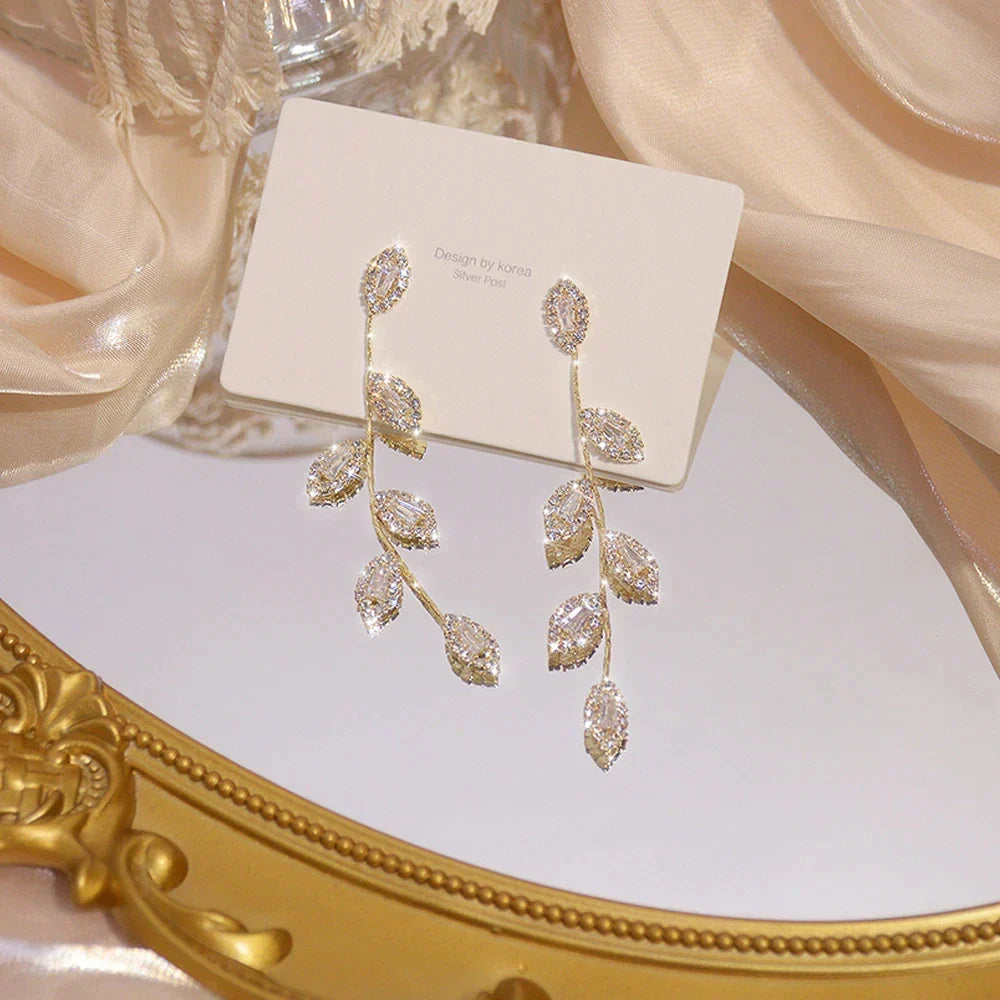 Elegant women's long dangle earrings with delicate golden leaves. Gold-plated, perfect fashion accessory.