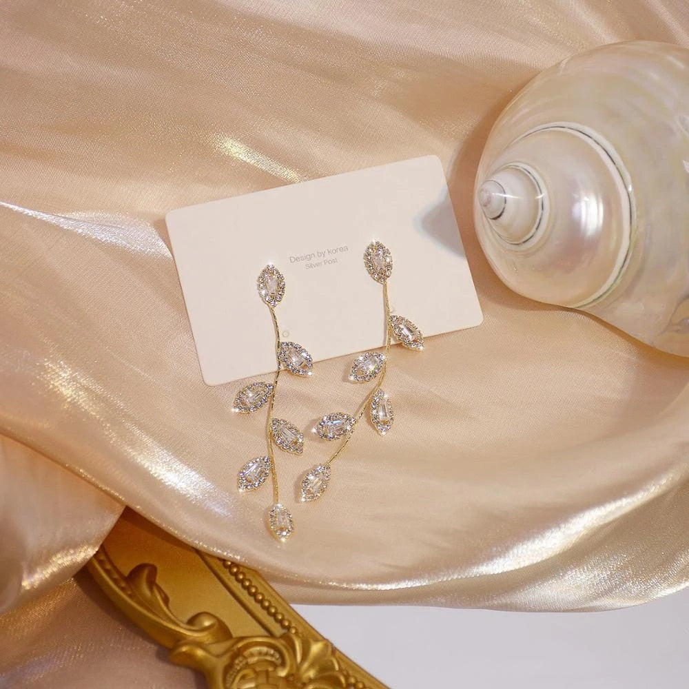 Delicate gold-plated long dangle earrings for women, featuring elegant golden leaf design. Hypoallergenic jewelry.