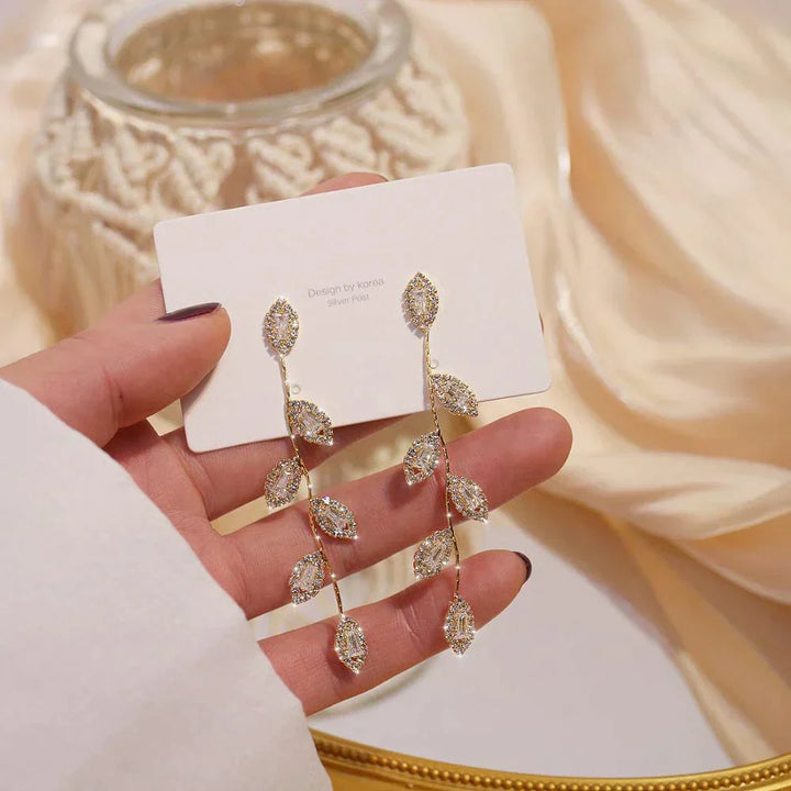 Stunning women's long dangle earrings, gold-plated with intricate golden leaf motif. Elegant and delicate jewelry.
