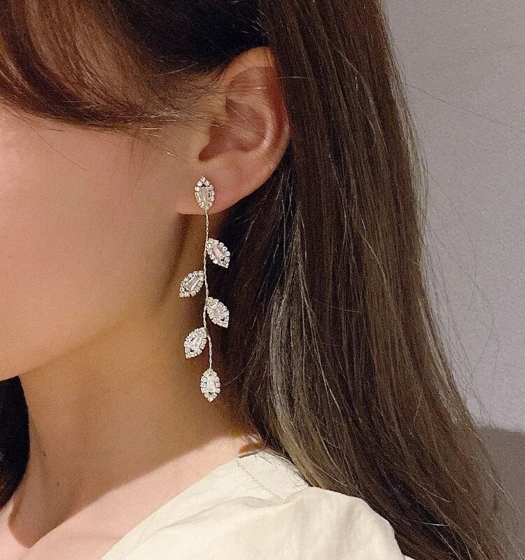 Hypoallergenic long dangle earrings for women, featuring elegant gold-plated delicate golden leaves. Fashion jewelry.