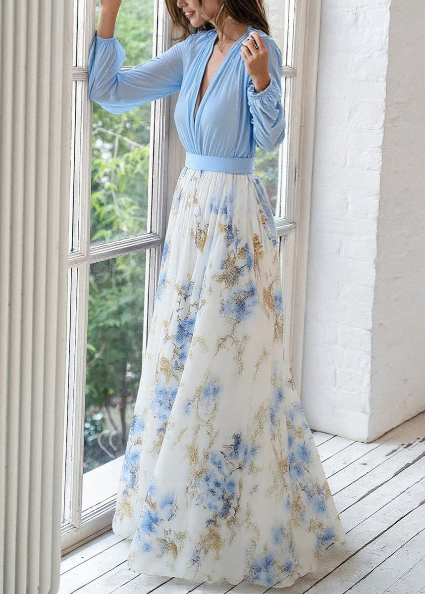 Light blue flowing women's maxi dress featuring long sleeves, a deep V-neck, and a delicate floral print.