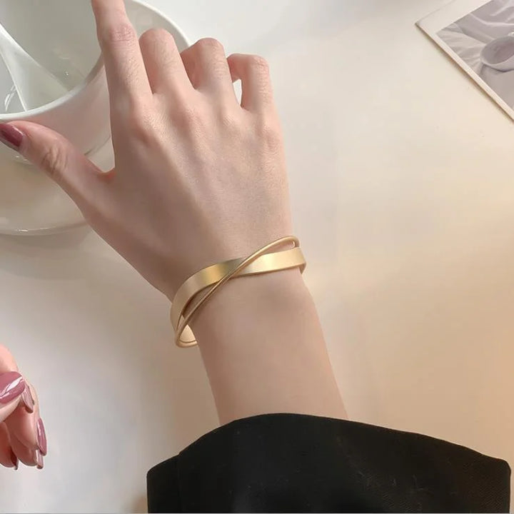 Close-up of a delicate women's matte gold infinity symbol bracelet. Elegant gold jewelry, perfect for any wrist.