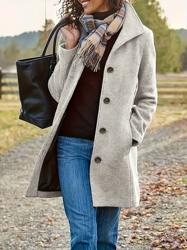 Elegant women's mid-length trenchcoat with classic lapel & button front. Perfect tailored outerwear for fall.