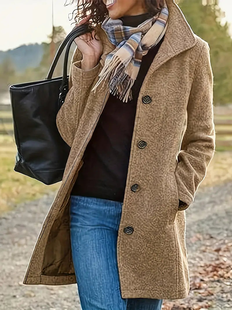 Classic women's fall/winter trenchcoat. Mid-length design with lapel collar & prominent button-front closure.