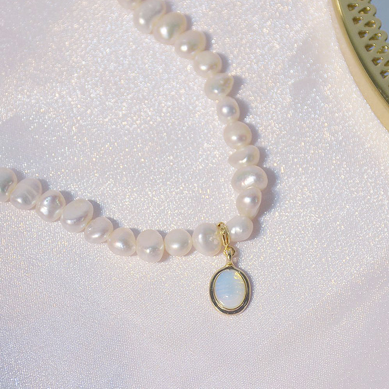 Stylish women's mini pearl charm necklace displayed. Short pearl necklace, a delicate and versatile piece of jewelry.