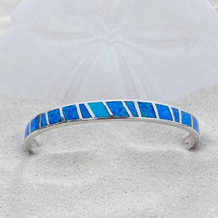 Sparkling blue opal gemstone bracelet for women, set in polished silver, evoking a serene ocean aesthetic.