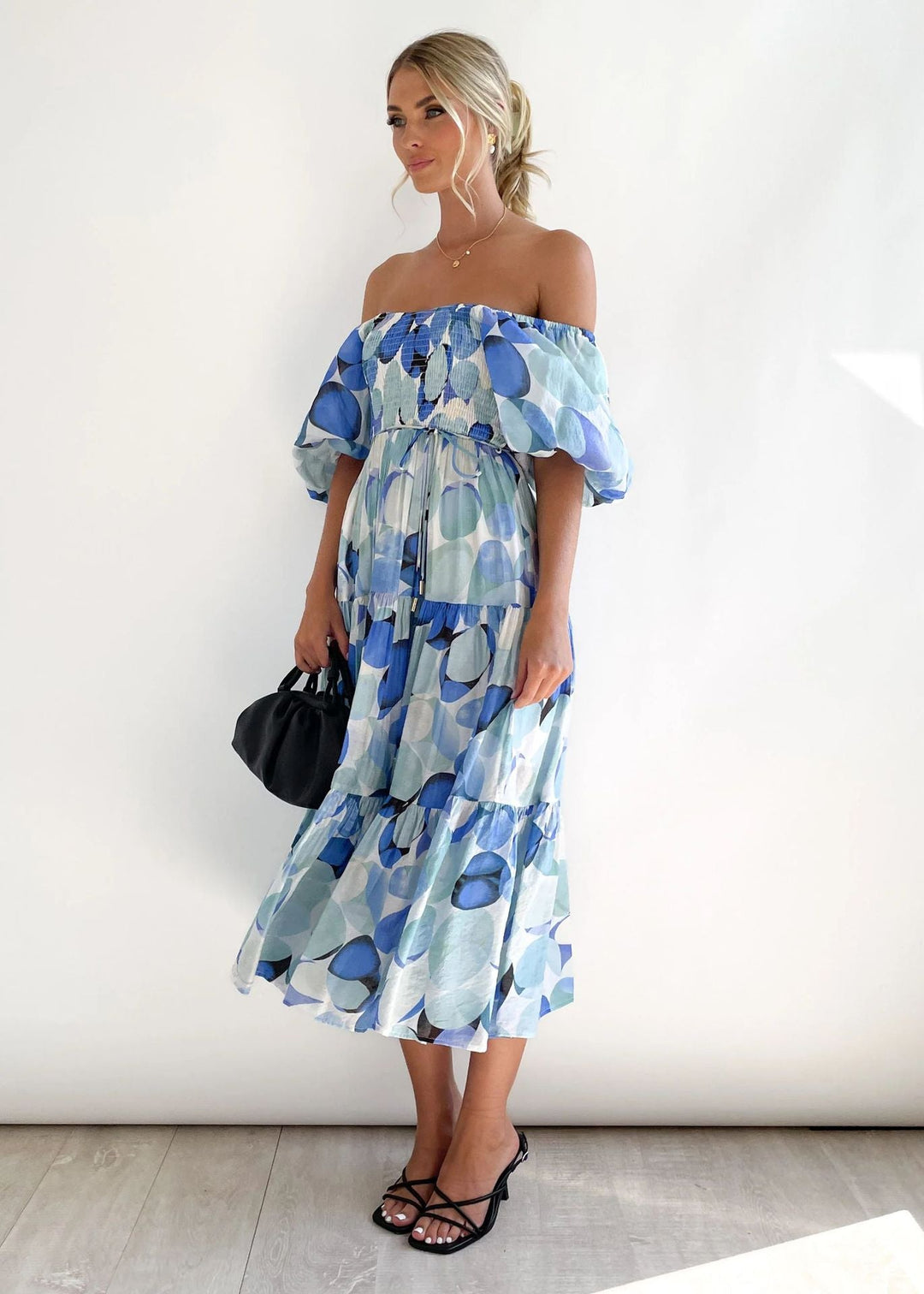 Trendy women's off-shoulder midi dress with playful ruffles. A chic and elegant piece for modern women's fashion.