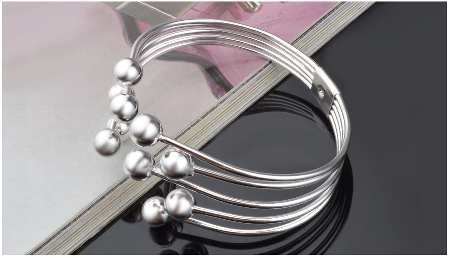 Sophisticated women's wide open cuff bracelet featuring delicate silver beads. A sleek and modern wristband.
