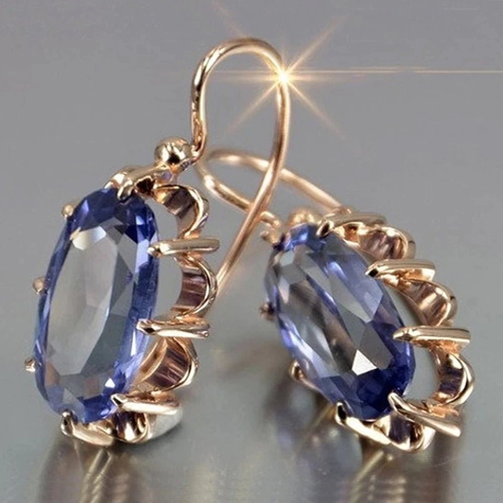 Elegant women's oval gold earrings featuring sparkling zirconia stones, perfect for a fine jewelry gift.