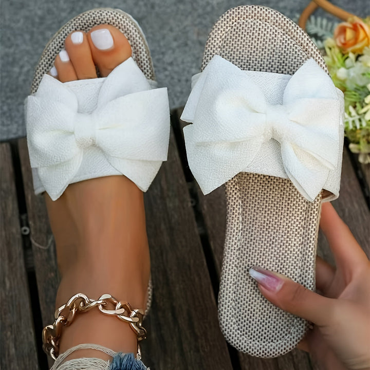 Comfortable women's flat pearl slide sandals with delicate bow, ideal for summer beach & casual elegance.