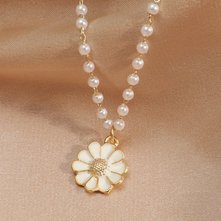Stylish women's sterling silver necklace featuring a beautiful pearl and intricate daisy floral pendant.
