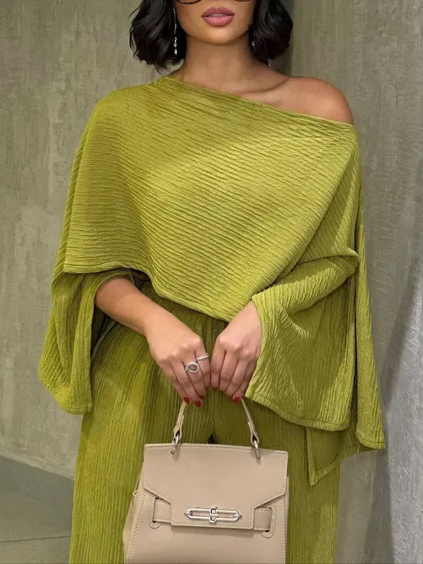 Elegant women's pleated chiffon two-piece set, perfect for summer resort wear. Flowing wide-leg pants & stylish one-shoulder top.