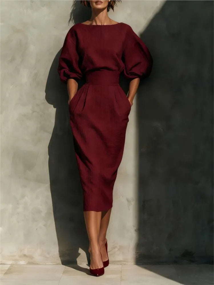 Women's fashion midi dress featuring sophisticated pleats, voluminous lantern sleeves, and a chic wrap skirt design.