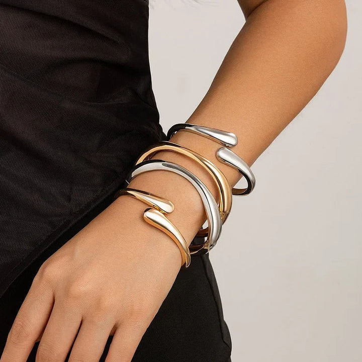 Modern irregular cross bracelet for women, polished alloy with versatile mixed metal silver and gold tones.