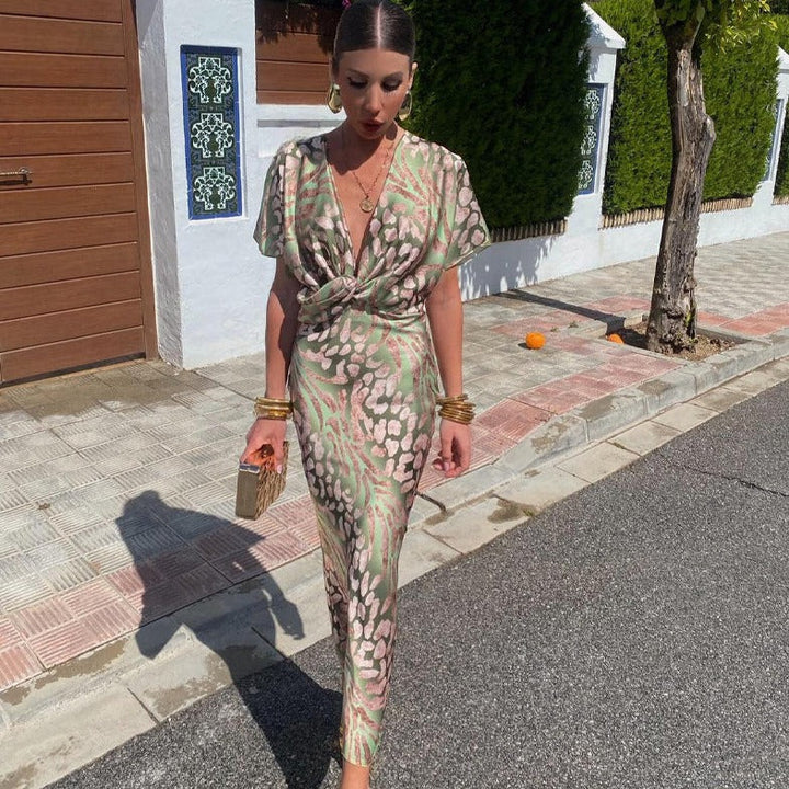 Elegant women's printed maxi dress with twist front, V-neck, and draped sleeves, perfect for a wedding guest.