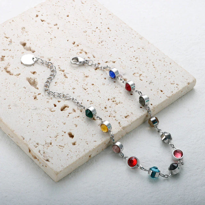 Hand modeling an elegant women's rainbow crystal charm bracelet. Shimmering colorful beads make a statement.