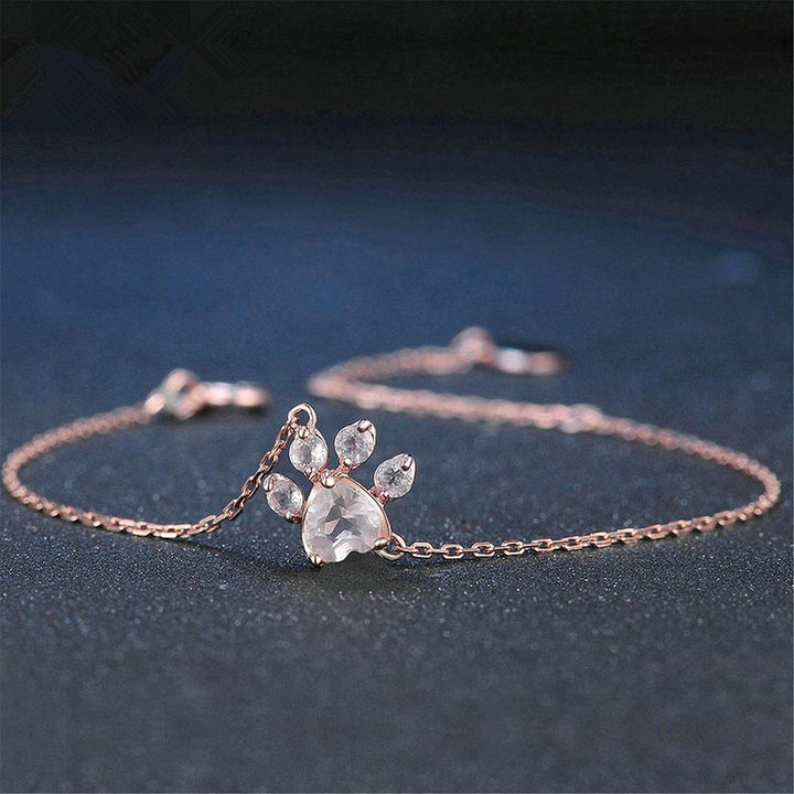 Elegant women's rose quartz bracelet with delicate cat paw charm. Adjustable rose gold-tone jewelry, perfect for cat lovers.