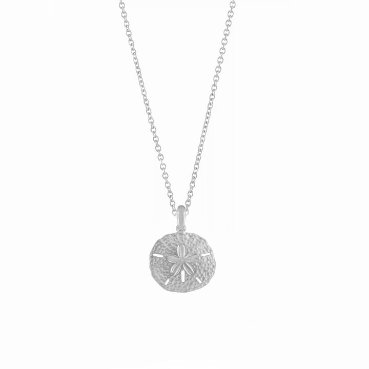 Hypoallergenic silver sand dollar necklace, a delicate coastal charm pendant. Elegant women's ocean jewelry.