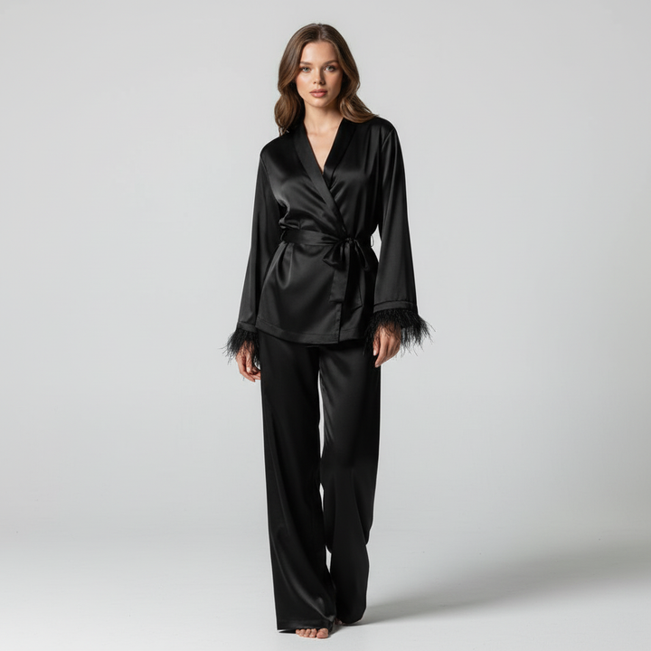 Detail shot of the satin fabric and feather trim on an elegant women's two-piece lounge outfit.