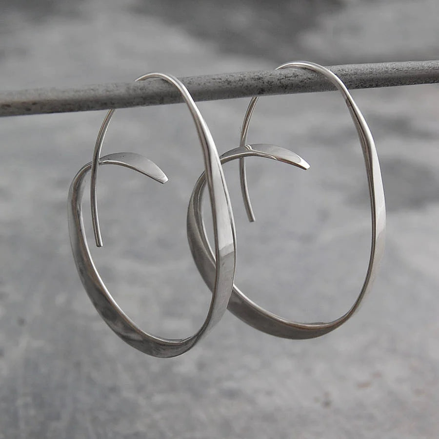 Elegant women's Serina spiral dangle earrings in gold. Modern artistic jewelry, perfect for a chic look.