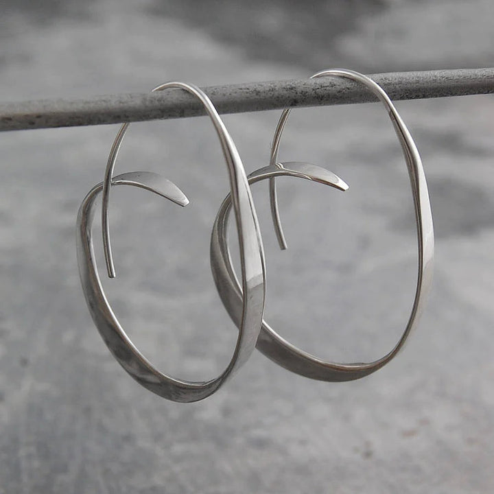 Elegant women's Serina spiral dangle earrings in gold. Modern artistic jewelry, perfect for a chic look.