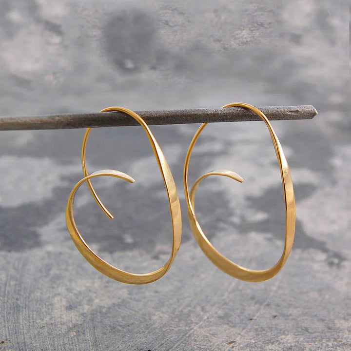 Modern women's Serina spiral dangle earrings. Artistic design in polished silver, elegant statement jewelry.
