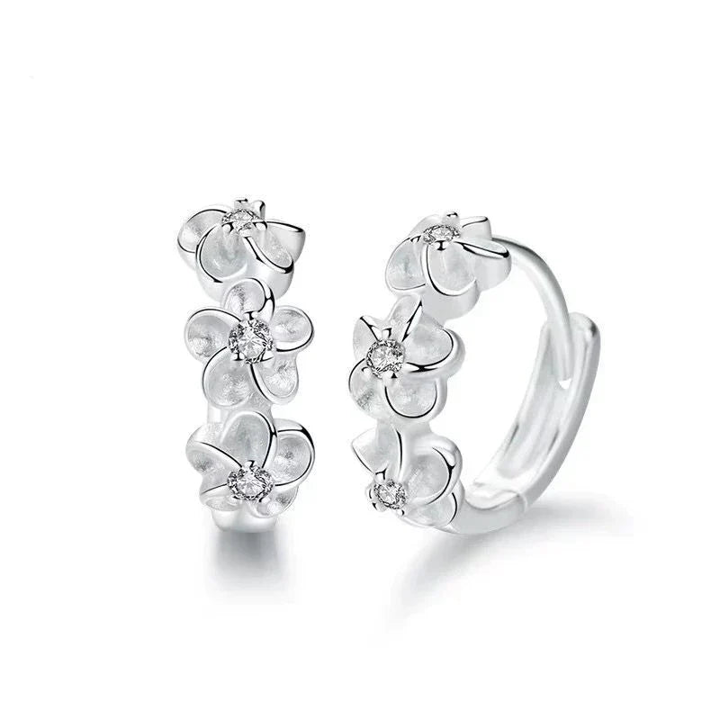 Detailed sterling silver floral earrings. Intricate petals and elegant design, delicate women's jewelry.