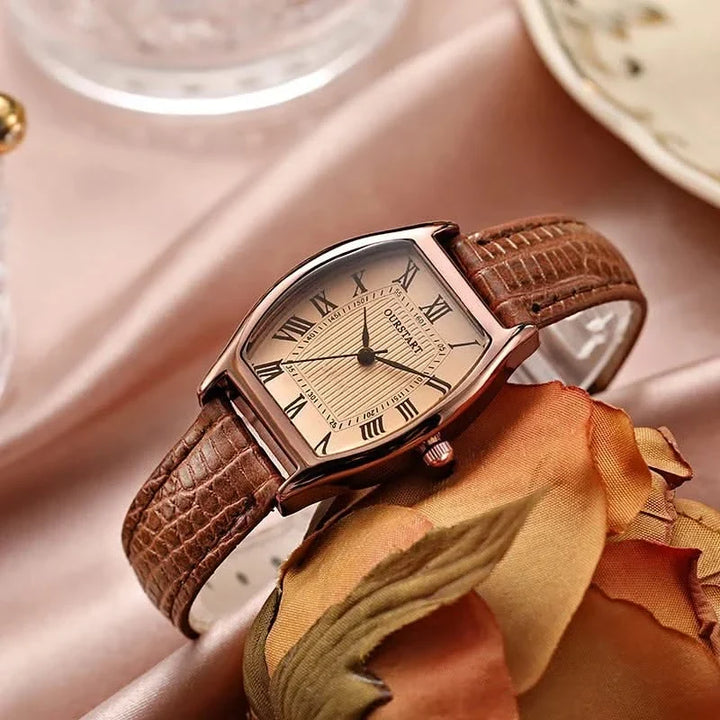 Close-up of a women's classic wristwatch dial showcasing elegant Roman numerals & a sleek silver-tone finish.