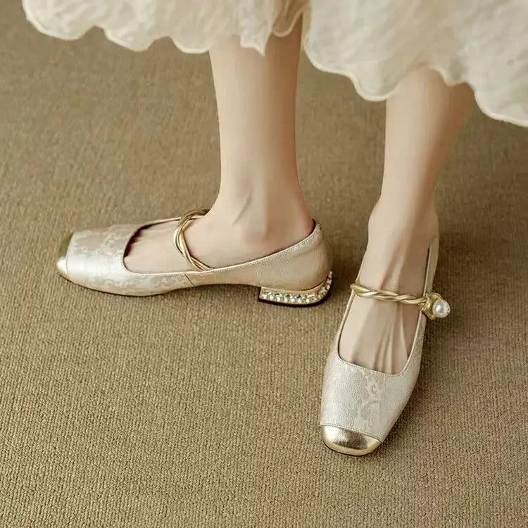 Sparkling women's Mary Janes with a delicate pearl strap, metallic toe & low heel. Elegant footwear.
