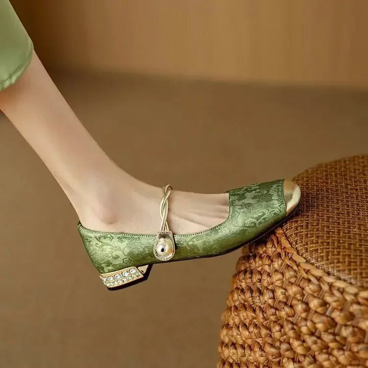 Beige sparkling Mary Janes for women, featuring a chic pearl strap, metallic toe, and low block heel.