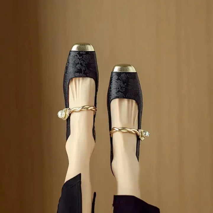 Women's elegant dress shoes: sparkling Mary Janes with a pearl strap, metallic toe, and low block heel.